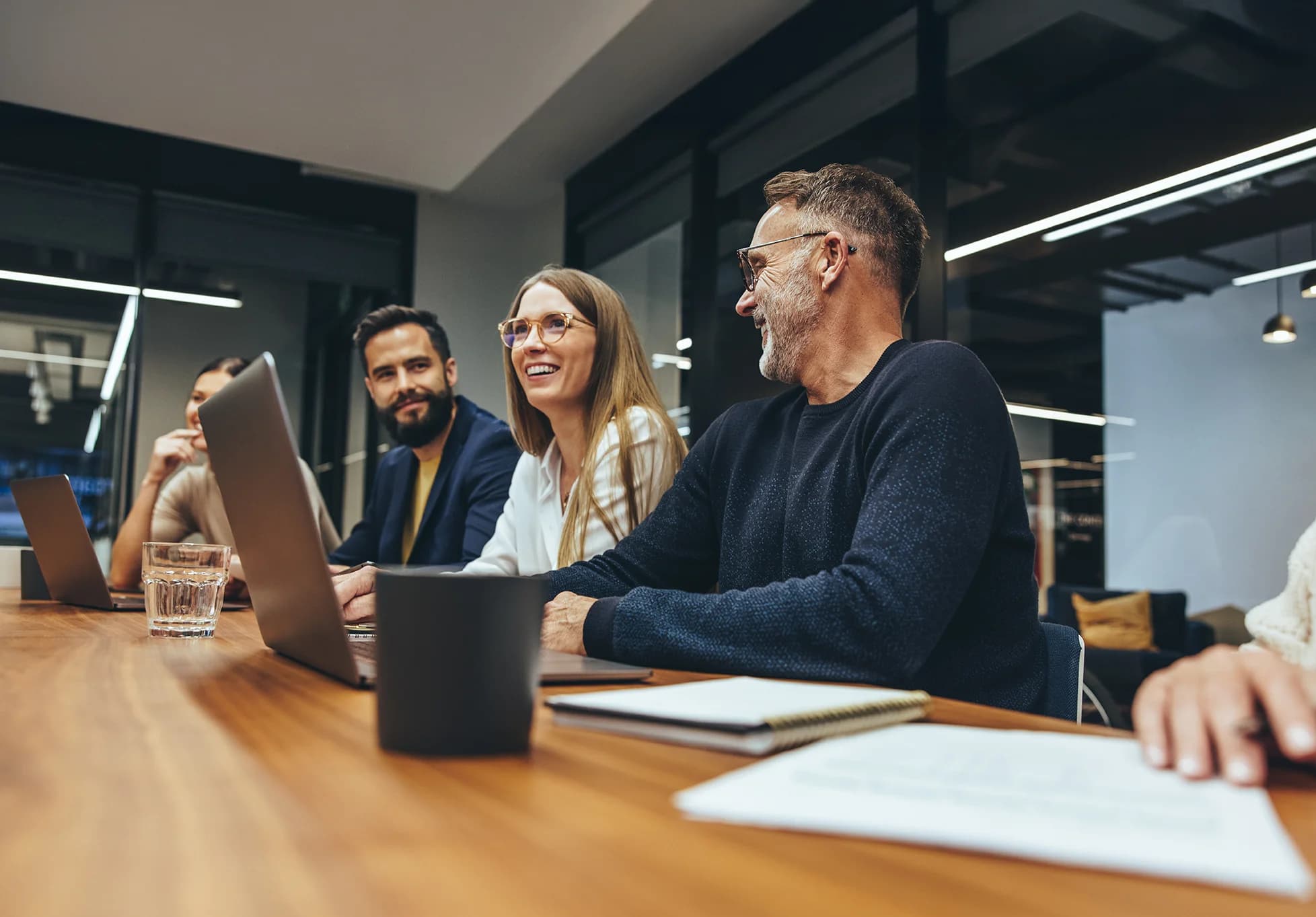 Successful group of businesspeople having a briefing in a boardroom. Happy businesspeople smiling while working together in a modern workplace. Diverse business colleagues collaborating on a project.