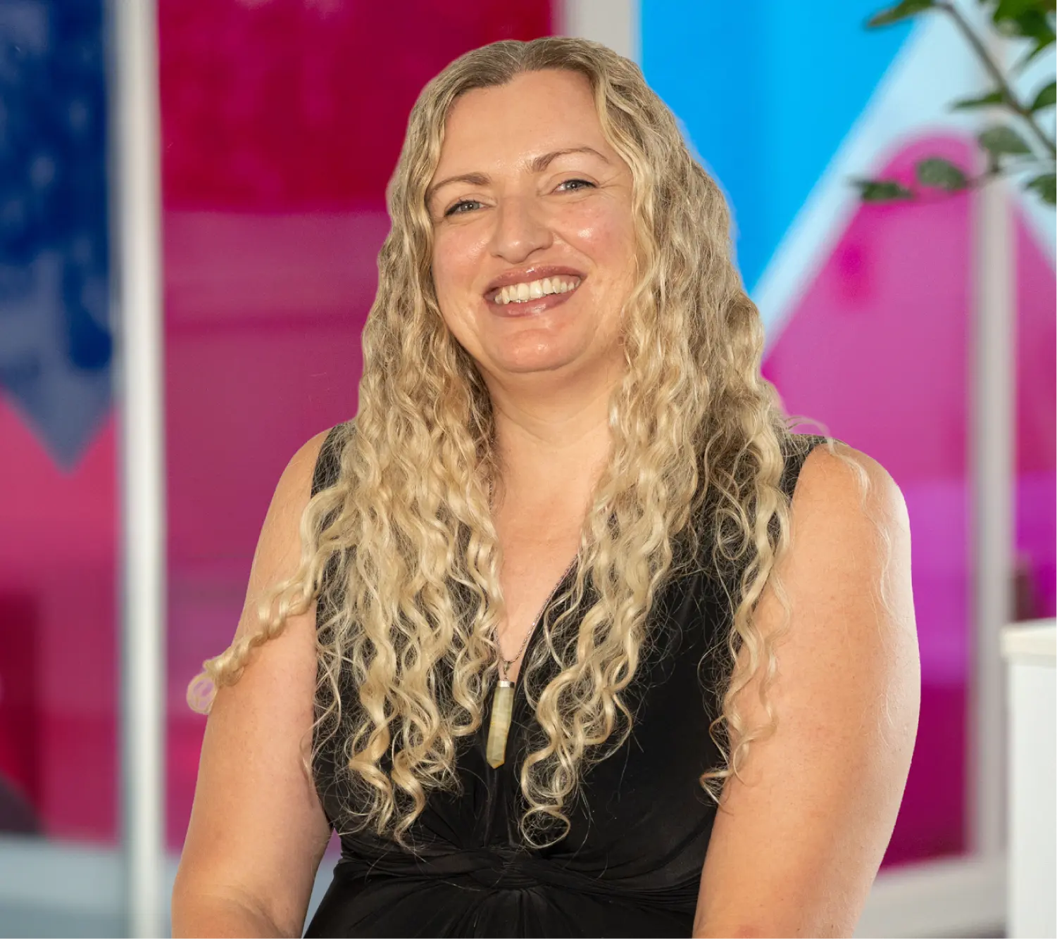 Photo of Lavinia Crosby, Commercial Retentions Executive at Utilita Business, sat in front of colourful glass panels.