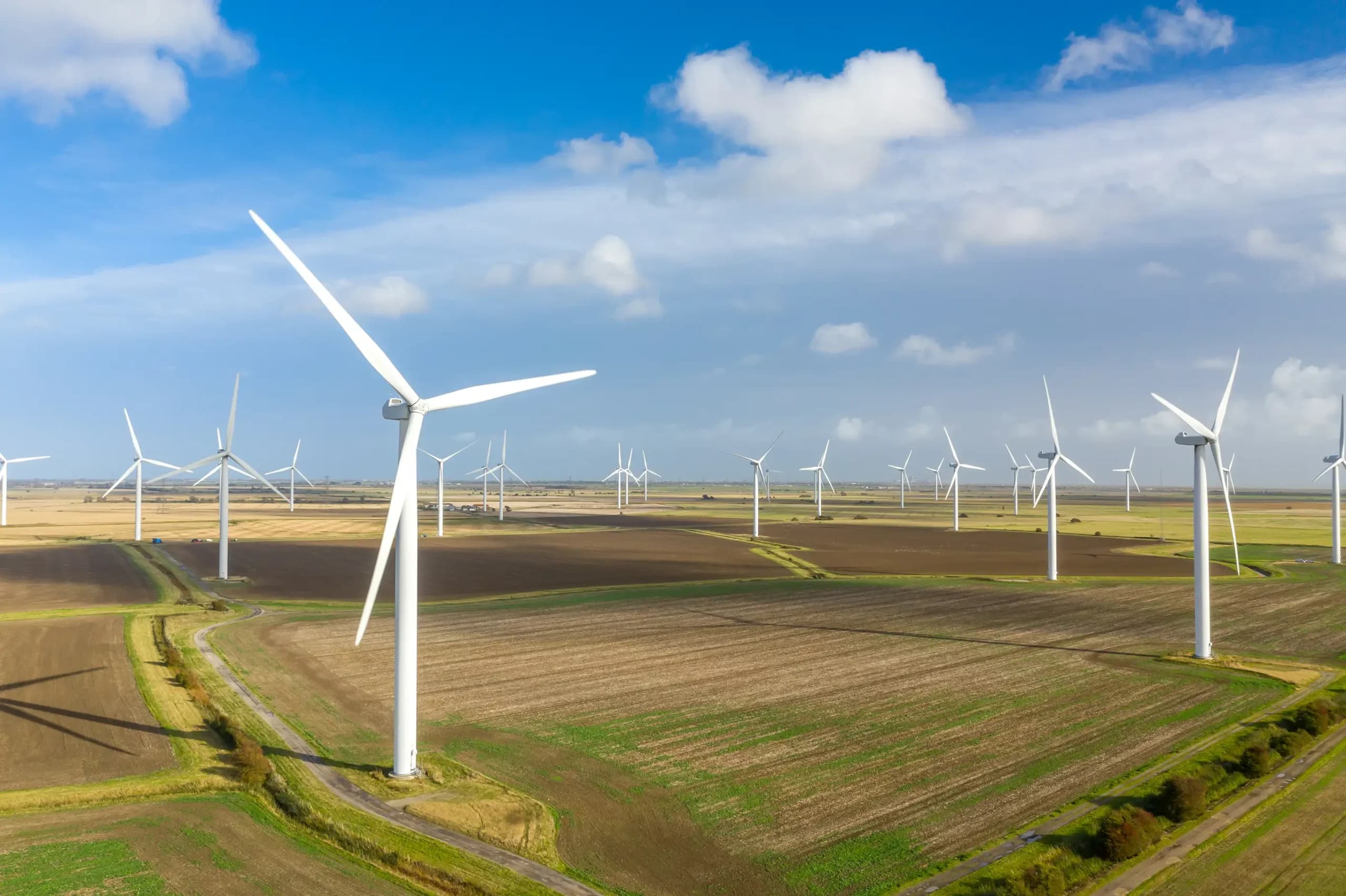 Wind turbine farm in a field, representing renewable electricity & Scope 2 emission reporting for businesses across the UK.